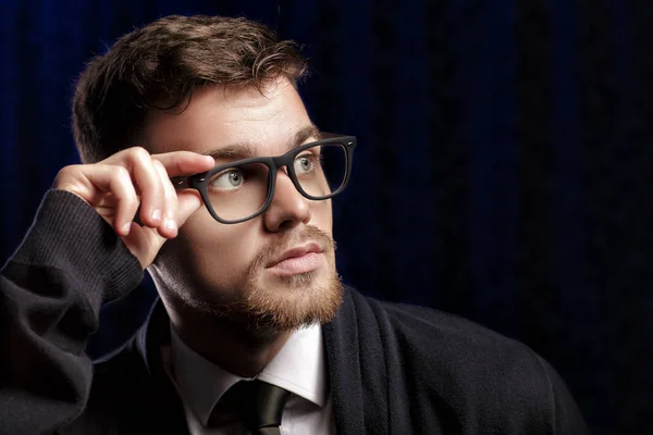 Portrait de beau jeune homme avec des lunettes et chemise blanche sur fond sombre — Photo