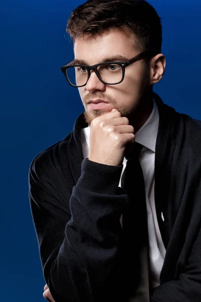 Портрет красивого молодого человека в очках и белой рубашке на синем фоне — стоковое фото