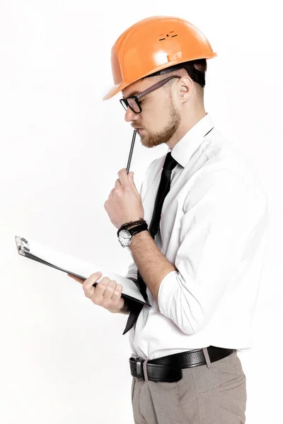 白い背景上のフォルダーにオレンジ色のヘルメットで若い建設エンジニアの肖像画 — ストック写真