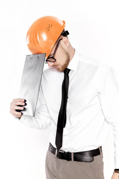 Porträtt av ung byggnadsingenjör i orange hjälm med mappen på vit bakgrund — Stockfoto