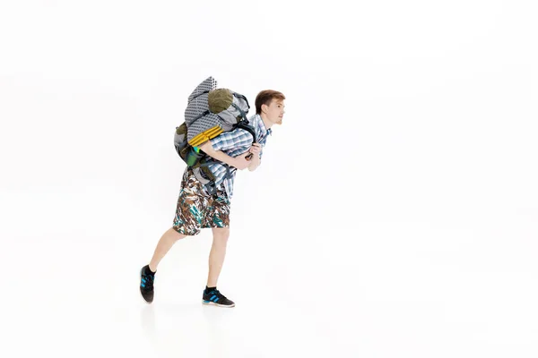 Joven turista con mochila corriendo sobre fondo blanco. excursionista llegó tarde — Foto de Stock