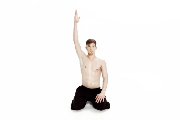 Joven haciendo ejercicios de yoga. Estudio sobre fondo blanco — Foto de Stock