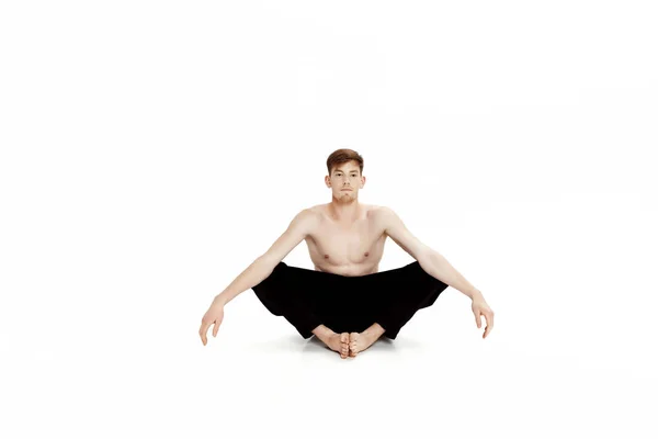 Giovanotto che fa esercizi di yoga. Studio girato su sfondo bianco — Foto Stock