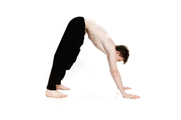 Young man doing yoga exercises. Studio shot on white background — Stock Photo, Image