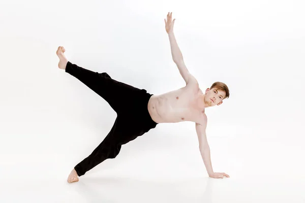 Fiatal férfi csinál jóga gyakorlatok. Stúdió felvétel-fehér háttér — Stock Fotó