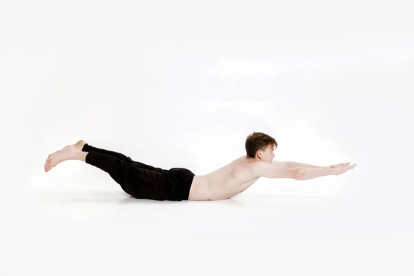 Jonge man doen yoga oefeningen. Studio opname op witte achtergrond — Stockfoto
