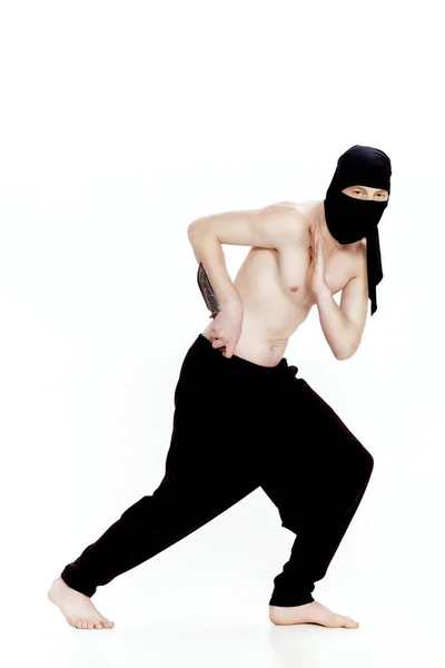 Ninja hombre sostiene cuchillo y está listo para atacar sobre fondo blanco —  Fotos de Stock