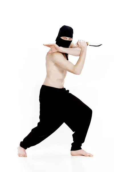 Ninja férfi kést tart, és az készen áll a támadásra, a fehér háttér — Stock Fotó