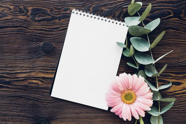 Flat lay pink flowers and diary on wooden background, top view. mock up — Stock Photo, Image
