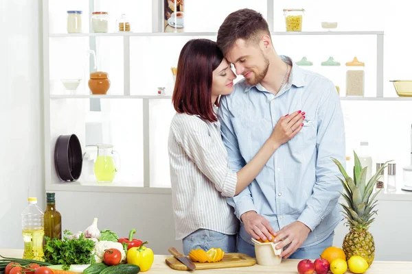 幸福的夫妇，在厨房做健康果汁杯鲜橙汁从恋爱 — 图库照片