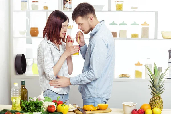 幸福的夫妇，在厨房做健康果汁杯鲜橙汁从恋爱 — 图库照片