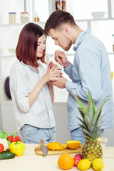 幸福的夫妇，在厨房做健康果汁杯鲜橙汁从恋爱 — 图库照片