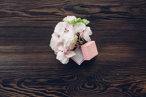 Rosa Box für Verlobungsring und Hortensie auf Holztisch, Ansicht von oben. — Stockfoto