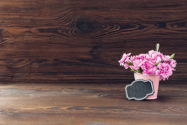 Strauß rosa Nelkenblüten in der Vase auf Holzgrund. Leerraum für Text — Stockfoto