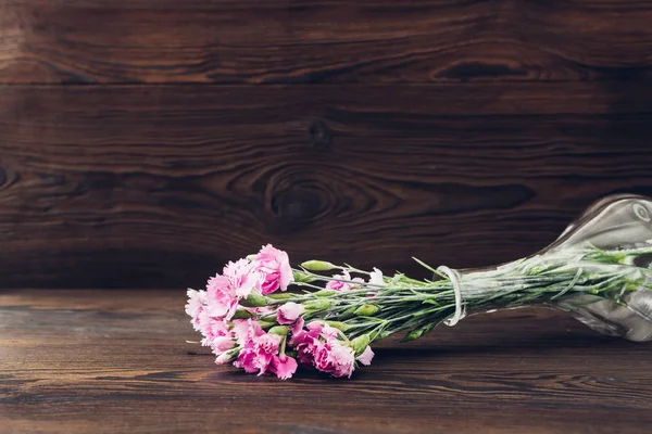 Strauß rosa Nelkenblüten in der Vase auf Holzgrund. Leerraum für Text — Stockfoto