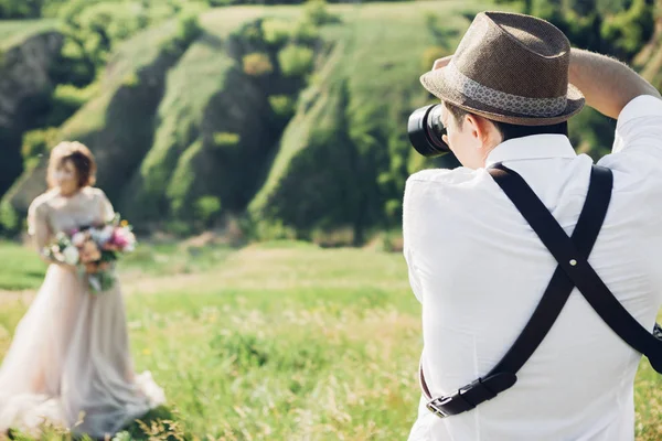 Весільний фотограф фотографує нареченого і нареченого на природі, вишукане художнє фото — стокове фото