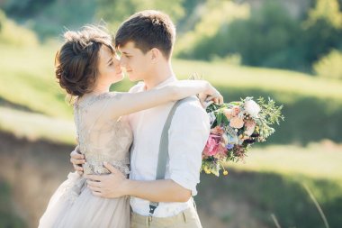 Düğün çift doğa üzerinde. Gelin ve damadın düğünde sarılma.