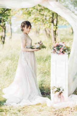 Gelin holding düğün pastası. Düğün pastası çiçeklerle süslenmiş