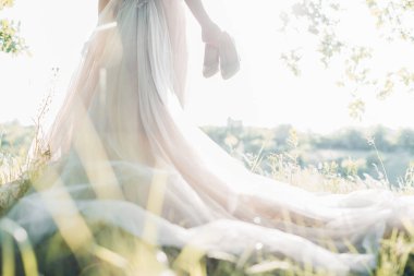 Gelin gelinlik ayakkabı Güneş karşı tutar. Güzel Sanatlar Fotoğraf