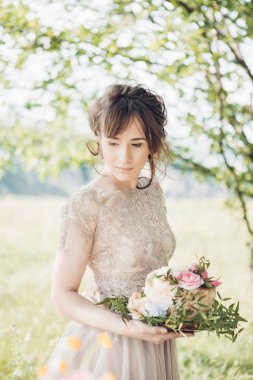 Gelin holding düğün pastası. Düğün pastası çiçeklerle süslenmiş