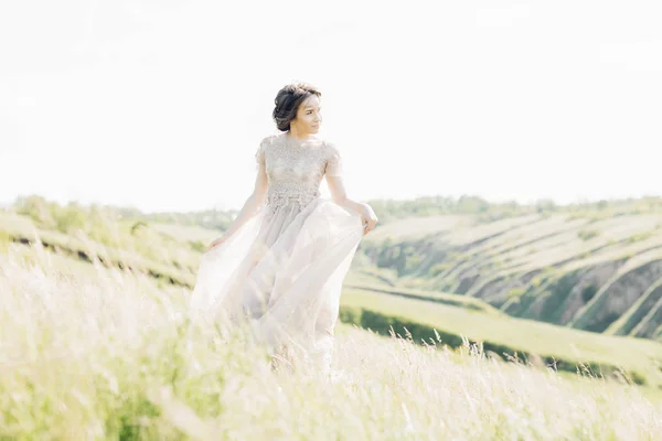 Fine art wedding photography. Beautiful bride with bouquet and dress with train in nature — Stock Photo, Image