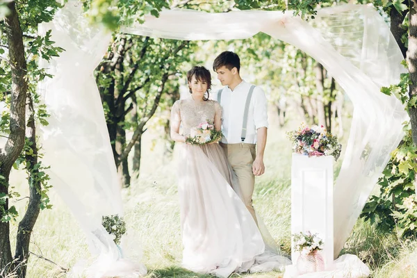 Casal de casamento na natureza. noiva e noivo com bolo no casamento . — Fotografia de Stock