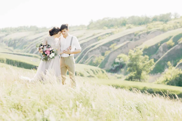 Casal de casamento na natureza. noiva e noivo abraçando no casamento . — Fotografia de Stock