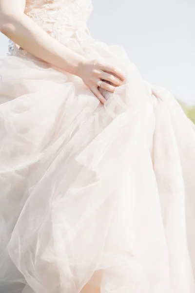 Hands of bride on wedding dress on sunny day. fine art photography. — Stock Photo, Image