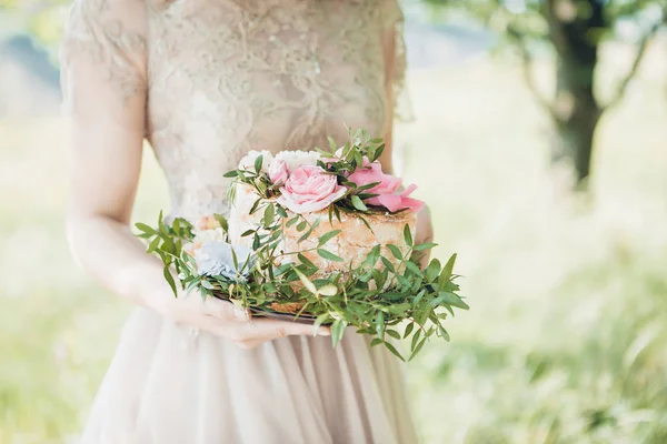 Noiva segurando bolo de casamento. bolo de casamento decorado com flores — Fotografia de Stock