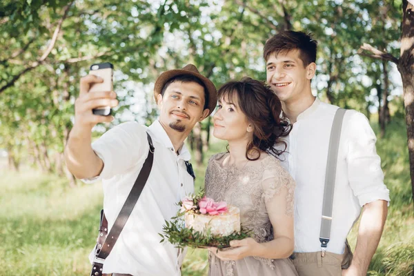 Весільний фотограф, наречена і наречений роблять селфі на природі — стокове фото