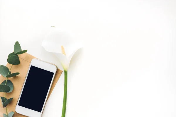 Boş ekran ve çiçeklerle beyaz arka planda, üstten görünüm hareket eden telefon. yukarı alay — Stok fotoğraf