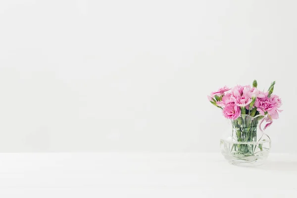 Strauß rosa Nelkenblüten in Vase auf weißem Tisch. Leerraum für Text — Stockfoto