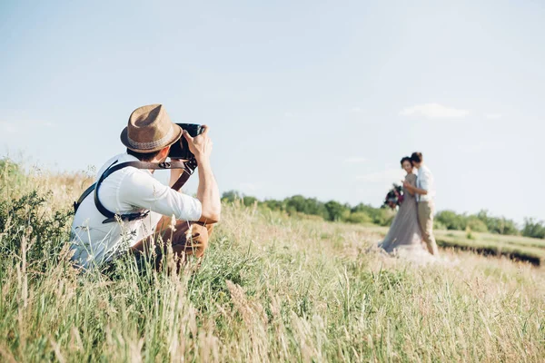 Svatební fotograf fotí nevěsty a ženicha v přírodě, umělecká fotografie — Stock fotografie