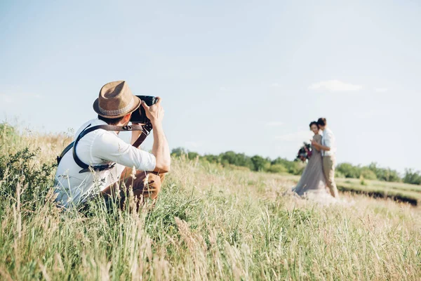 Fotógrafo de casamento tira fotos de noiva e noivo na natureza, foto de arte — Fotografia de Stock