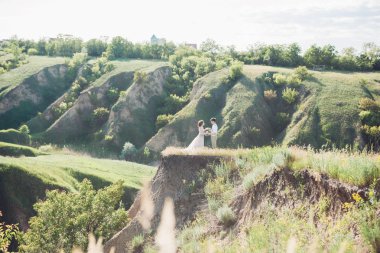 Düğün çift doğa üzerinde. Gelin ve damadın düğünde sarılma.