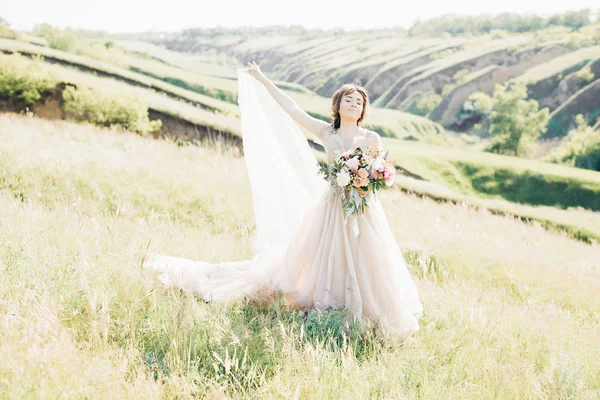 Fotografia de casamento de arte. Bela noiva com buquê e vestido com trem na natureza — Fotografia de Stock