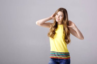 Gülümseyen ve kameraya bakarak uzun saçlı güzel genç esmer kadın