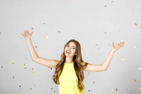 Hermosa mujer morena feliz con el pelo largo sonriendo y confeti cae por todas partes. tiempo de fiesta — Foto de Stock