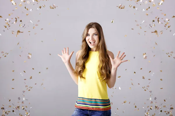 Hermosa mujer morena feliz con el pelo largo sonriendo y confeti cae por todas partes. tiempo de fiesta — Foto de Stock