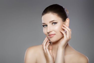 güzel kadının mavi gözler ile yüz ve taze cilt temiz. kız yüzünü elleriyle dokunuyor.