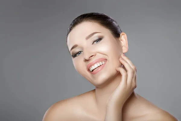 Rosto de mulher com olhos azuis e pele fresca limpa. Belo sorriso e dentes brancos — Fotografia de Stock