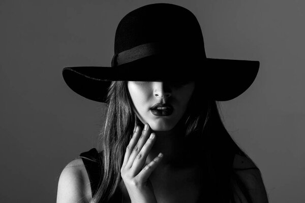 Black and white portrait of a beautiful sexy woman in a black hat