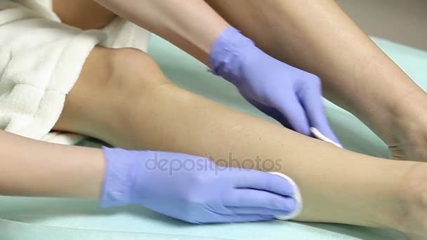 Cosmetologist σκουπίζει τα πόδια ασθενείς με βαμβάκι σφουγγάρι πριν από τη διαδικασία. απολύμανση — Αρχείο Βίντεο