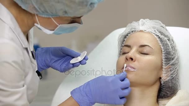 Esteticista aplica crema anestésica en los labios t del paciente antes del procedimiento de aumento de labios — Vídeos de Stock