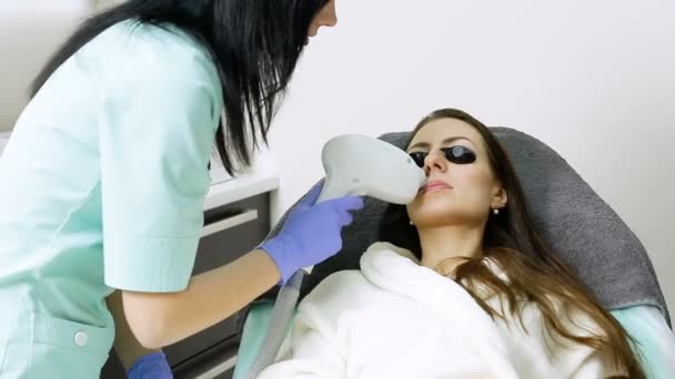 Kosmetolog laserowe usuwanie włosów na twarzy pacjenta. Procedura depilacji — Wideo stockowe