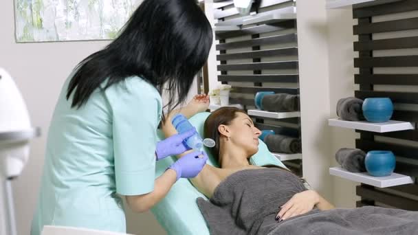 Kosmetolog stosuje żel do pachy pacjenta przed zabiegiem depilacji — Wideo stockowe