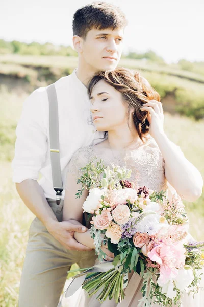 Casal de casamento na natureza. noiva e noivo abraçando no casamento . — Fotografia de Stock