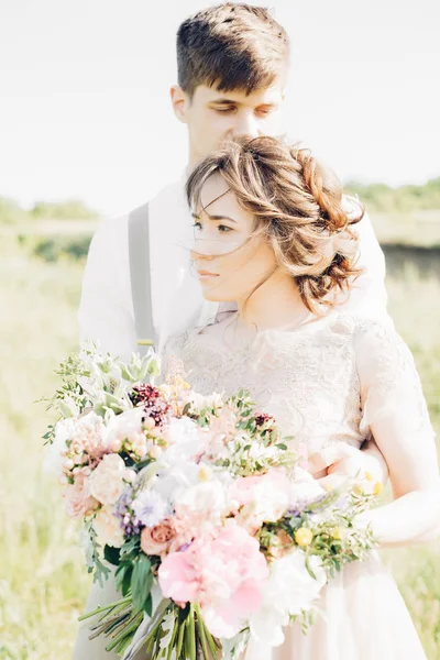 Casal de casamento na natureza. noiva e noivo abraçando no casamento . — Fotografia de Stock