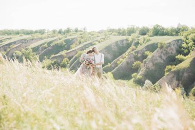 Düğün çift doğa üzerinde. Gelin ve damadın düğünde sarılma.