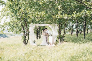 Düğün çift doğa üzerinde. Gelin ve damadın düğünde sarılma.